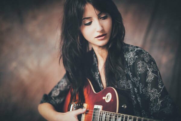 Hermosa chica tocando la guitarra