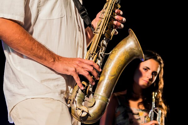 Une musicienne jette un coup d œil derrière un saxophone