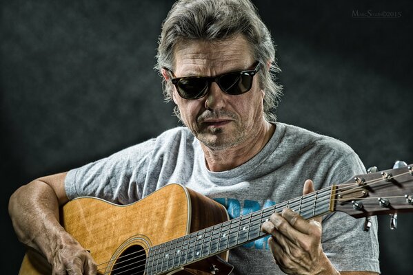 Jerry Wall in black glasses with guitar