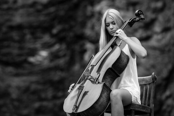 Foto in bianco e nero di una ragazza con un violoncello