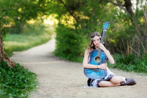 Blaue Gitarre in den Händen einer Brünette