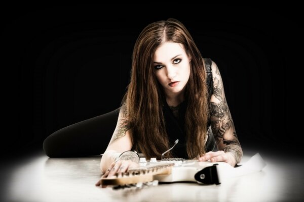 Photo of a girl with a guitar on a black background