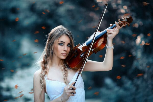 Chica con violín en el bosque jugando