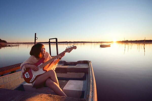 Chica con guitarra en el barco