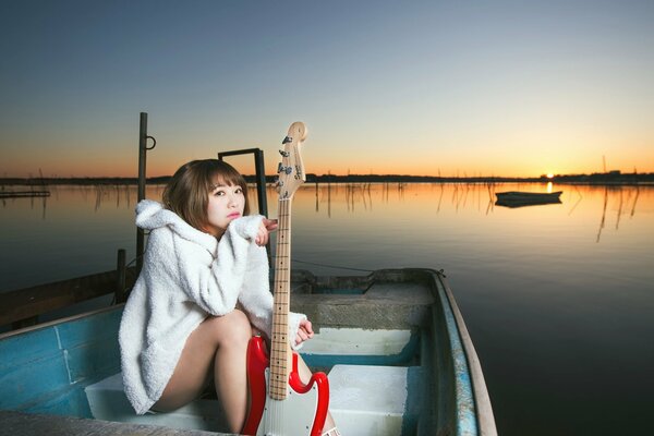 Fille solitaire avec une guitare sur un bateau