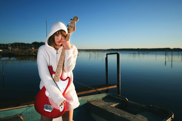 Fille avec une guitare sur un bateau