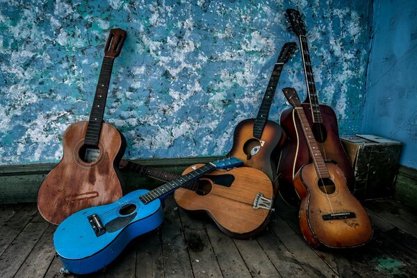 Six old guitars piled in the corner