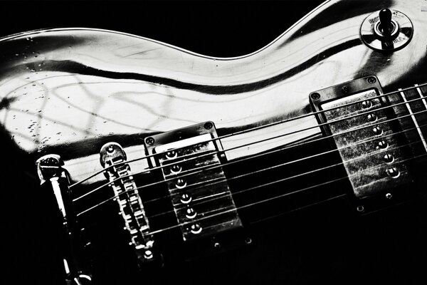 Parte del cuerpo de la guitarra en primer plano en blanco y negro