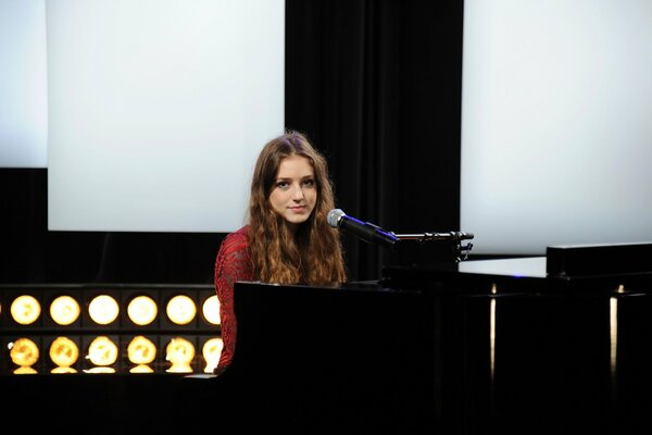 Chanteur britannique assis au piano