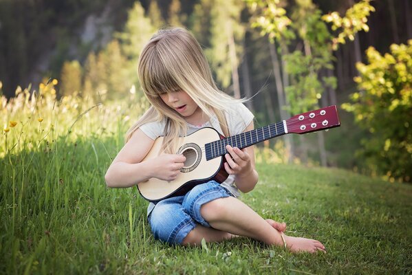 Девочка играет на гитаре на природе