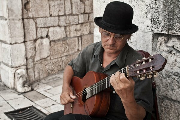 Mann Gitarre Brille Hut auf der Treppe