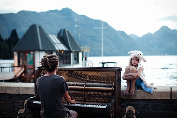 Puesta de sol en nueva Zelanda. El piano y la niña en el sombrero