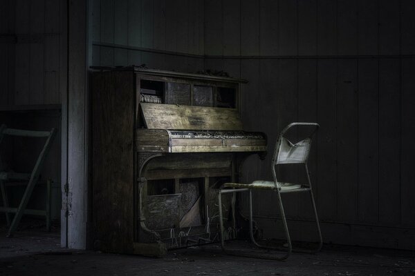 Pianoforte antico e sedia in una casa abbandonata