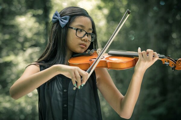 The girl is a violinist. Summer day