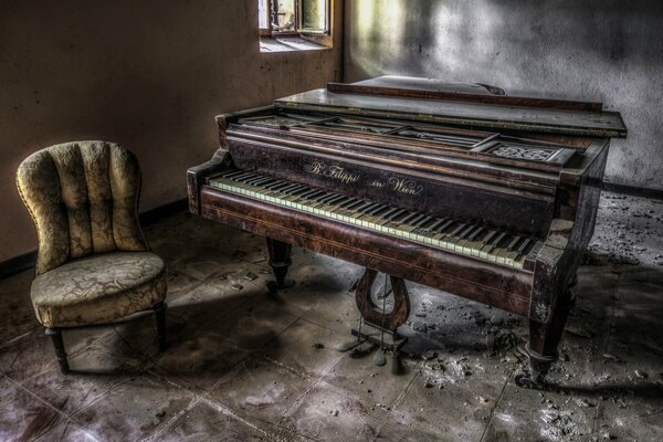 An armchair and an old piano in an abandoned house