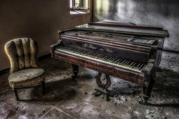Кресло и старинное пианино в заброшенном доме