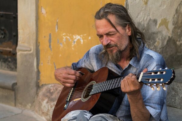 A man on the street plays the guitar