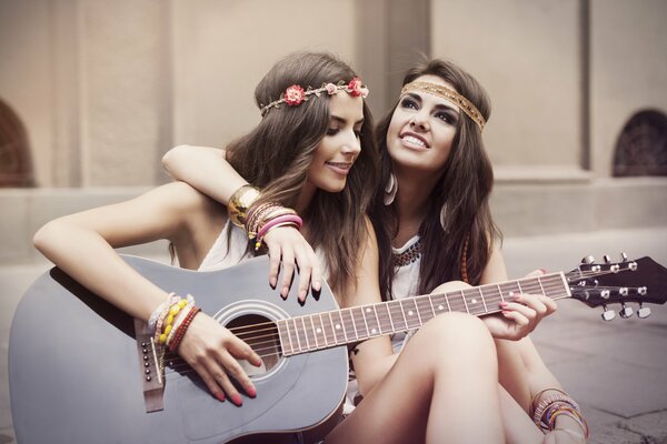 Two hippie girls play guitar