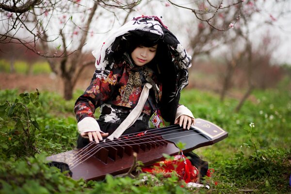 Ragazza con strumento musicale in giardino