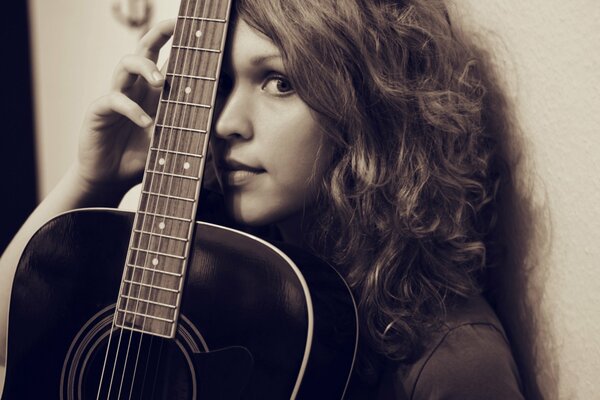 Hermosa chica con guitarra negra asiática