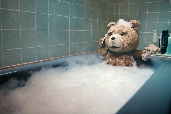 Ours Ted du film le Troisième Extra se baigne dans un bain de mousse