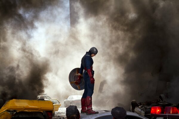 Capitan America in piedi con uno scudo contro il fumo