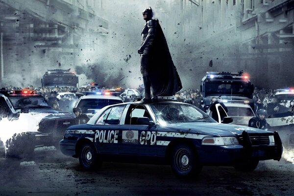 Batman standing on a police car