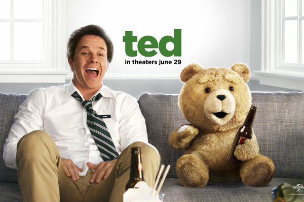 Les personnages du film The Third Extra Ted et Mark Wahlberg sont assis sur le canapé en riant et en buvant de la bière