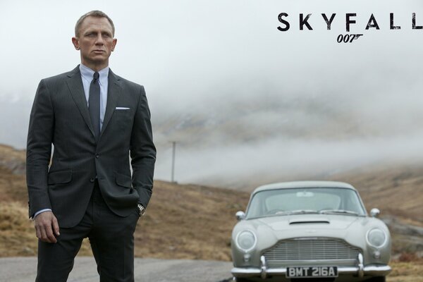 Agent 007 is standing by the car in a black suit