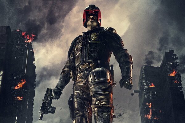 Le juge Dredd se tient sur fond de gratte-ciel en ruine