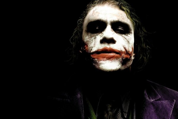 The image of the joker on a black background performed by Heath Ledger