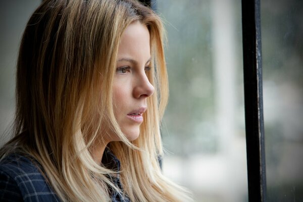 The girl looks out the window. Kate Beckinsale