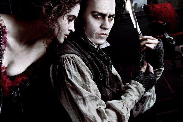 Johnny Depp with a straight razor in his hands and Helena Bonham-Carter in a dress with a cleavage next to him