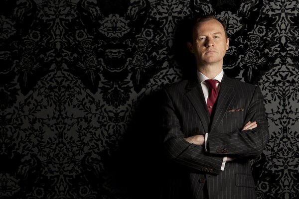 Mark Gatiss en traje de corbata roja