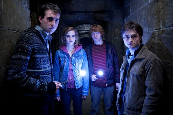 Персонажи фильма про Гарри Поттера со своими волшебными палочками в подземелье