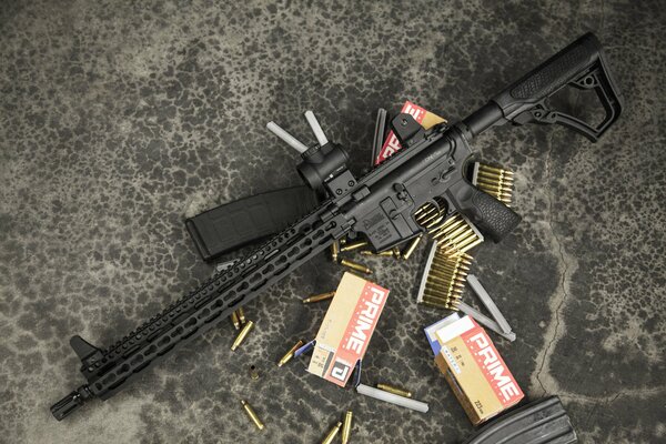 An assault rifle and cartridges scattered on the asphalt