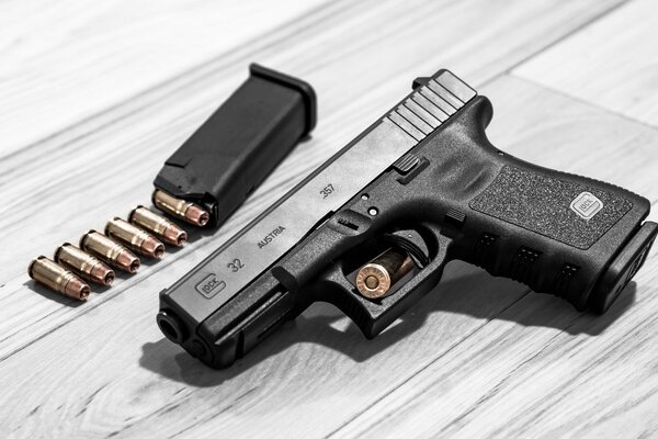 Austrian self-loading pistol glock 32 and cartridges on gray laminate