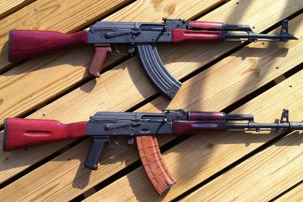 Two Kalashnikov assault rifles on the wooden floor