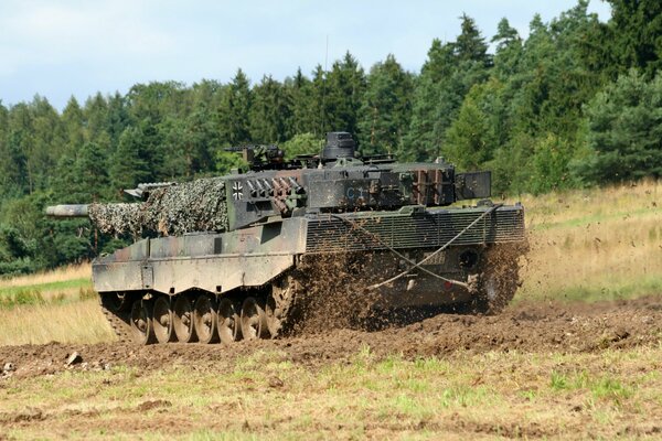 Un tanque transporta armas por el campo