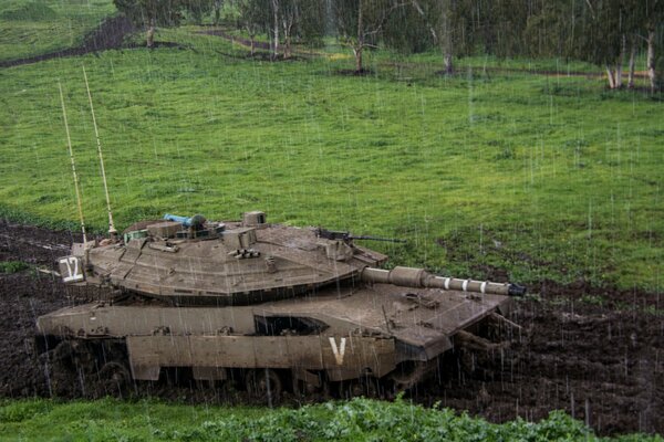 Tanque de batalla en el bosque bajo la lluvia