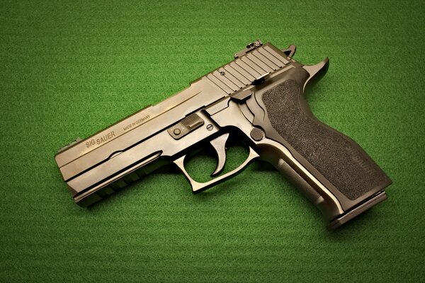 Pistol model SIG Sauer P226. Modern weapons. Gun on a green background