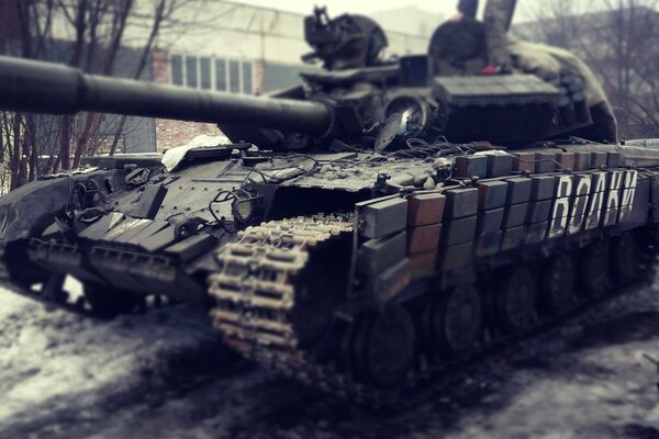 A battle tank at a brick building