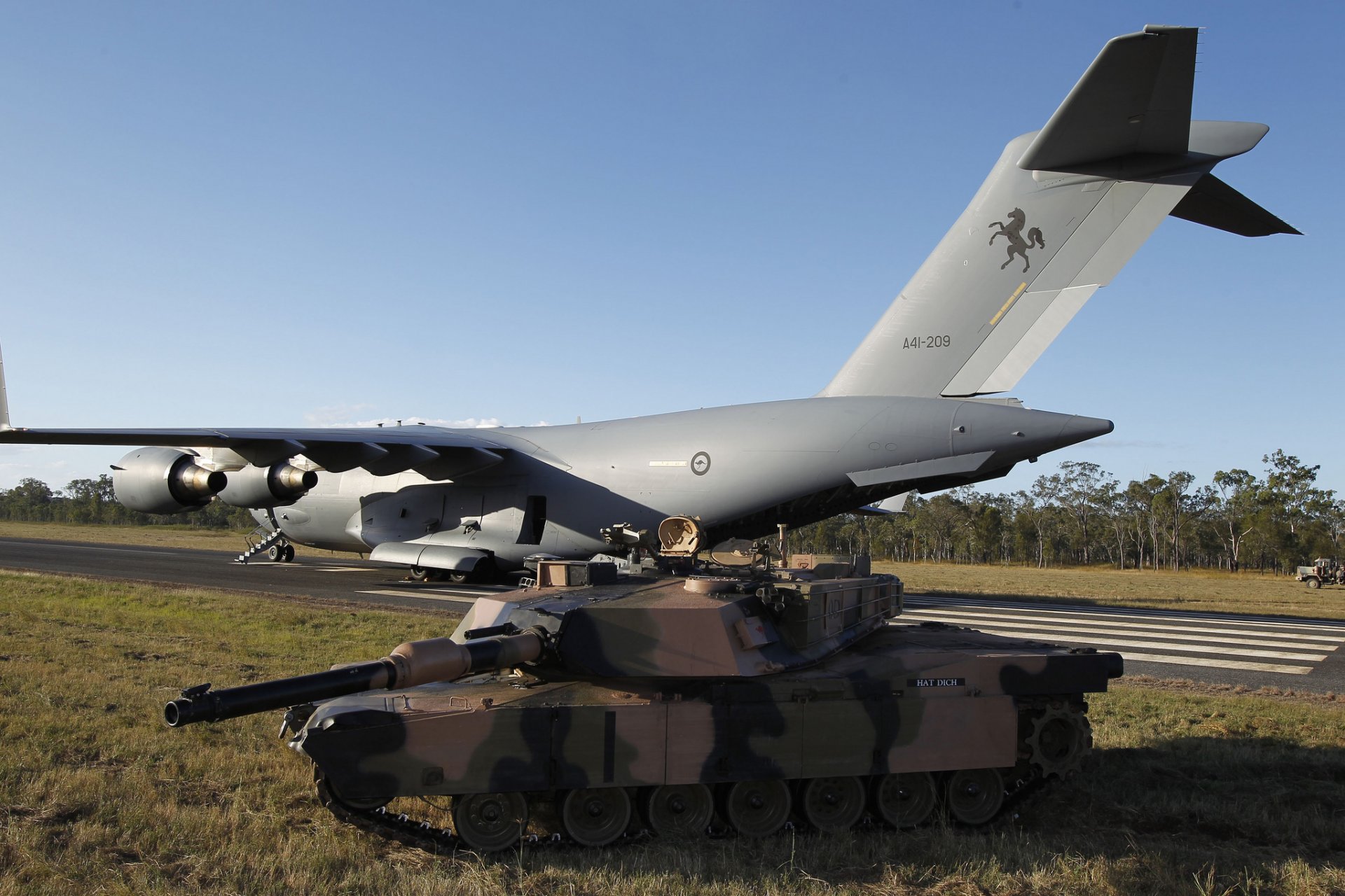 c-17a globemaster iii strategic military transport plane m1a1 abrams main battle tank airport