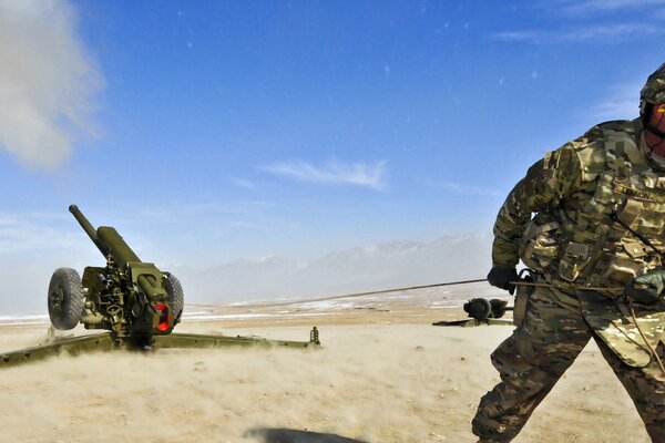 A soldier pulls a howitzer behind him