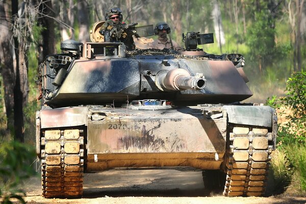 Der Panzer bewegt sich entlang einer Waldstraße und ein Mann ist darauf zu sehen