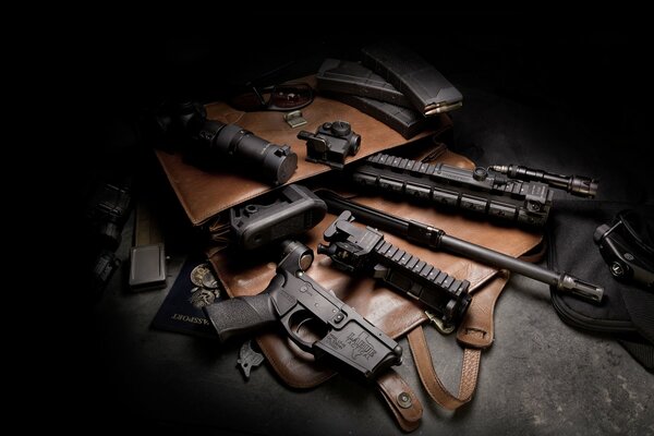 Broń i pistolety leżą na torbie na ciemnym tle