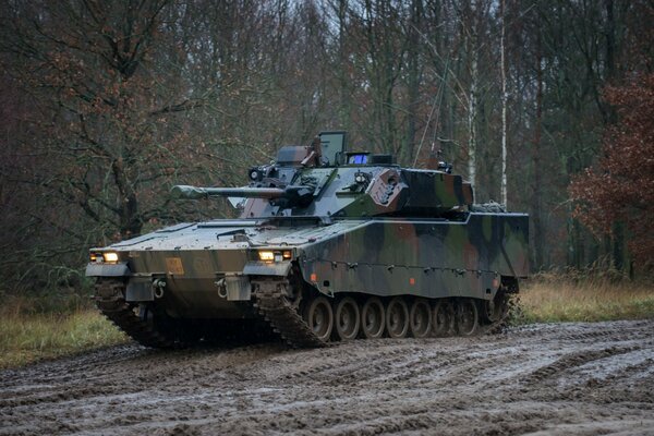 A combat vehicle rides through the mud