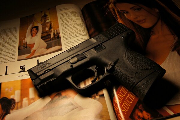 The stainless steel gun is lying on the magazine