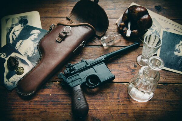 The gun is on the table next to the shot glass