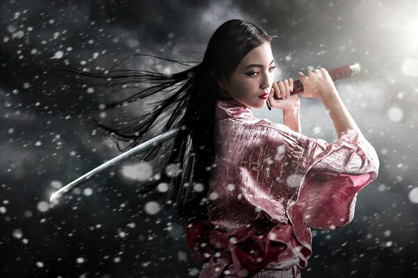 Belle fille avec une épée dans la neige